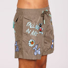 Khaki swim shorts side view with illustrated graphic and “Falling in art” text