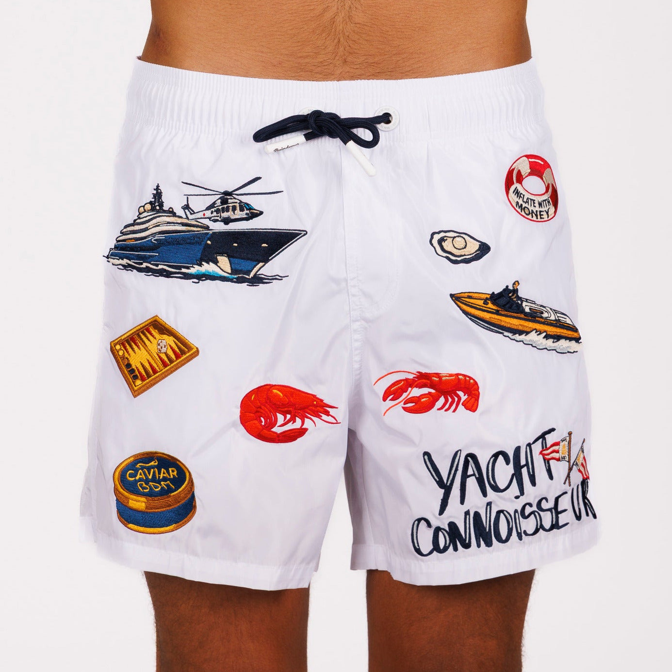 White swim shorts front view with illustrated graphic and “Yacht connoisseur” text