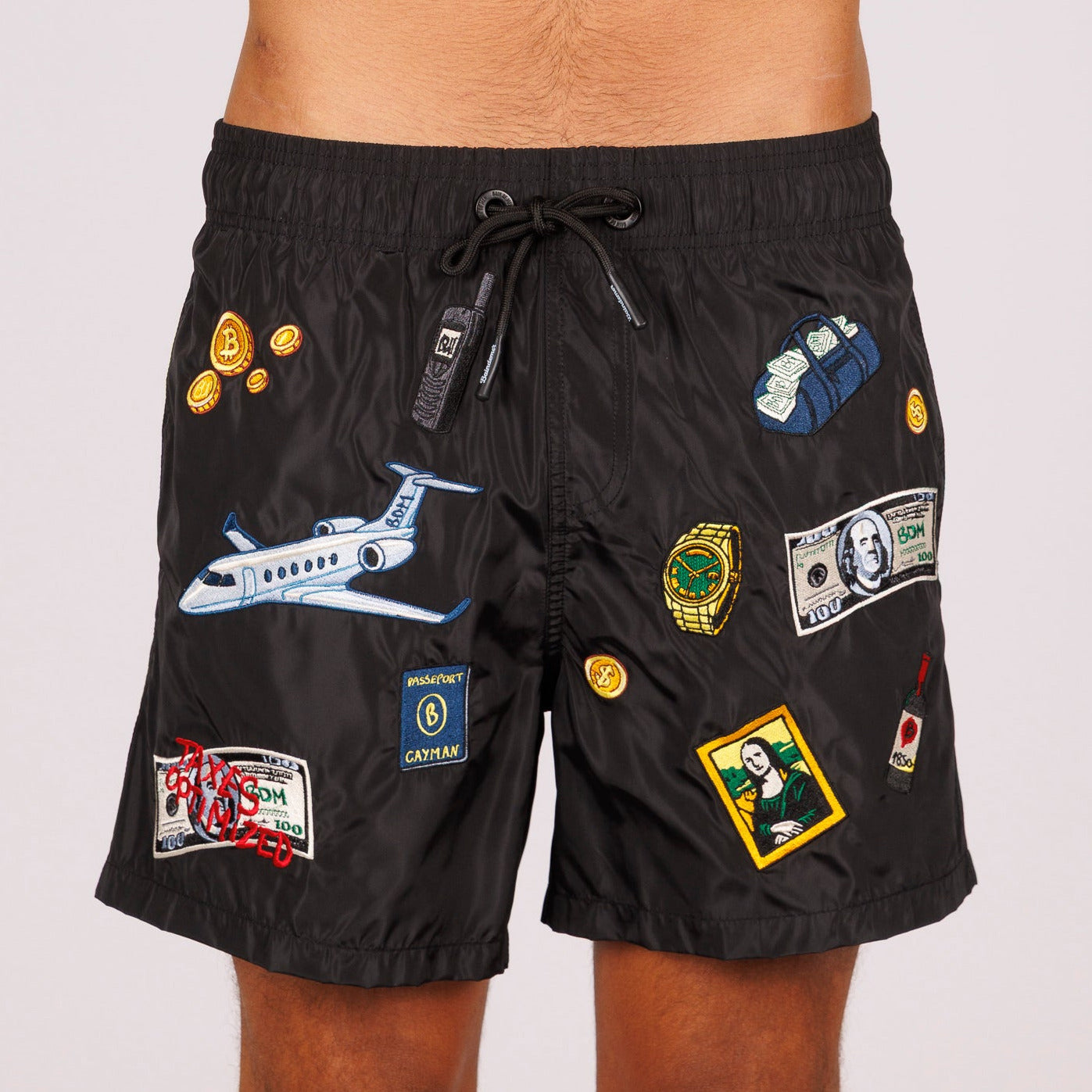 Black swim shorts front view with illustrated graphic and “Taxes optimized” text