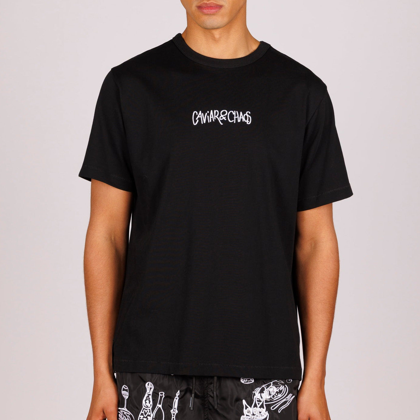 Black T-shirt front view with “Caviar&Chaos” text