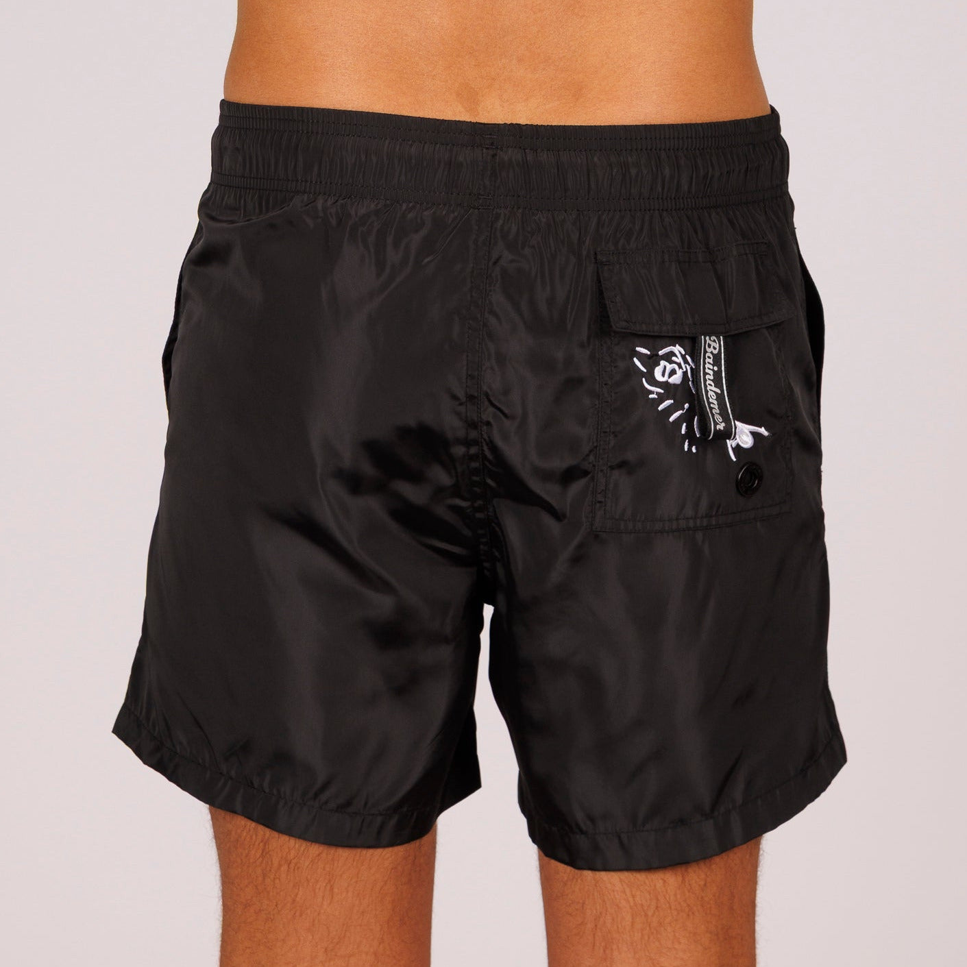 Black swim shorts back view with illustrated graphic 