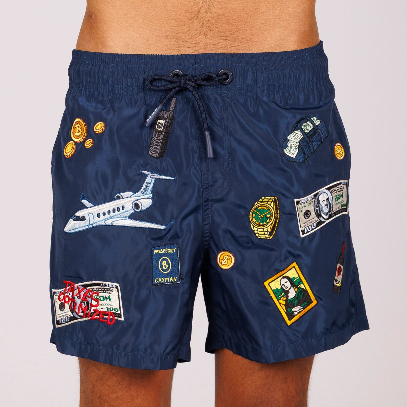 Navy blue swim shorts front view with illustrated graphic and “Taxes optimized” text